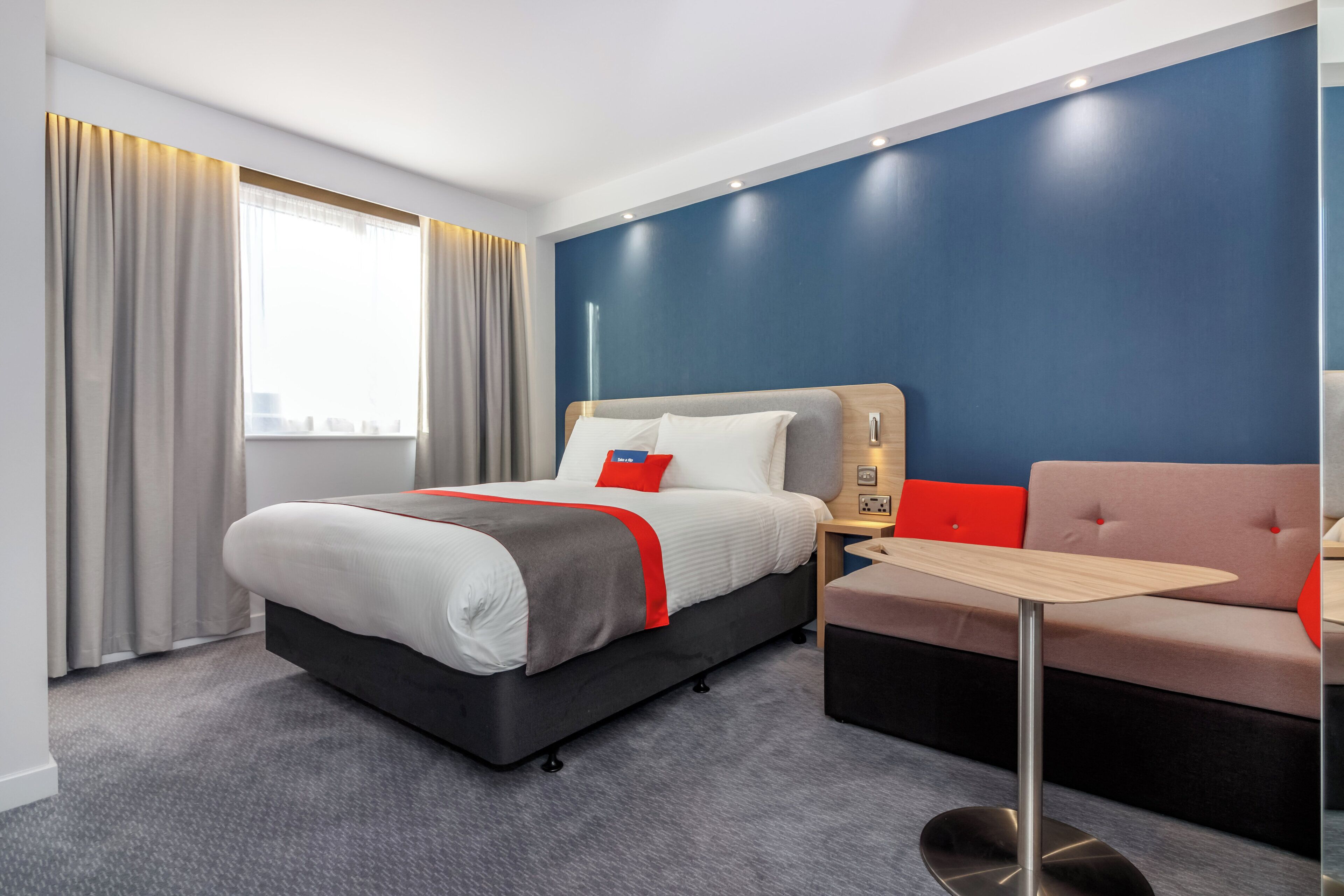 Ein Hotelzimmer mit einem Bett, einem kleinen Tisch und einem Sofa.