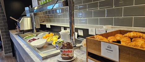 A breakfast buffet with various food items and labels indicating allergens.