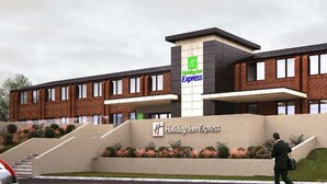 A Holiday Inn Express building with a brick facade, a central entrance, and a landscaped area with stairs leading up to the entrance. - Holiday Inn Express Wigan by IHG (Wigan)