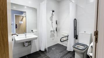 A modern bathroom with a white sink, a shower, and a toilet.