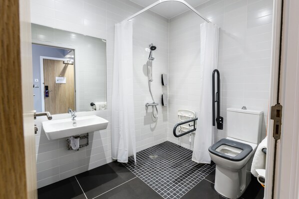 Une salle de bain moderne avec un lavabo blanc, une douche et des toilettes.