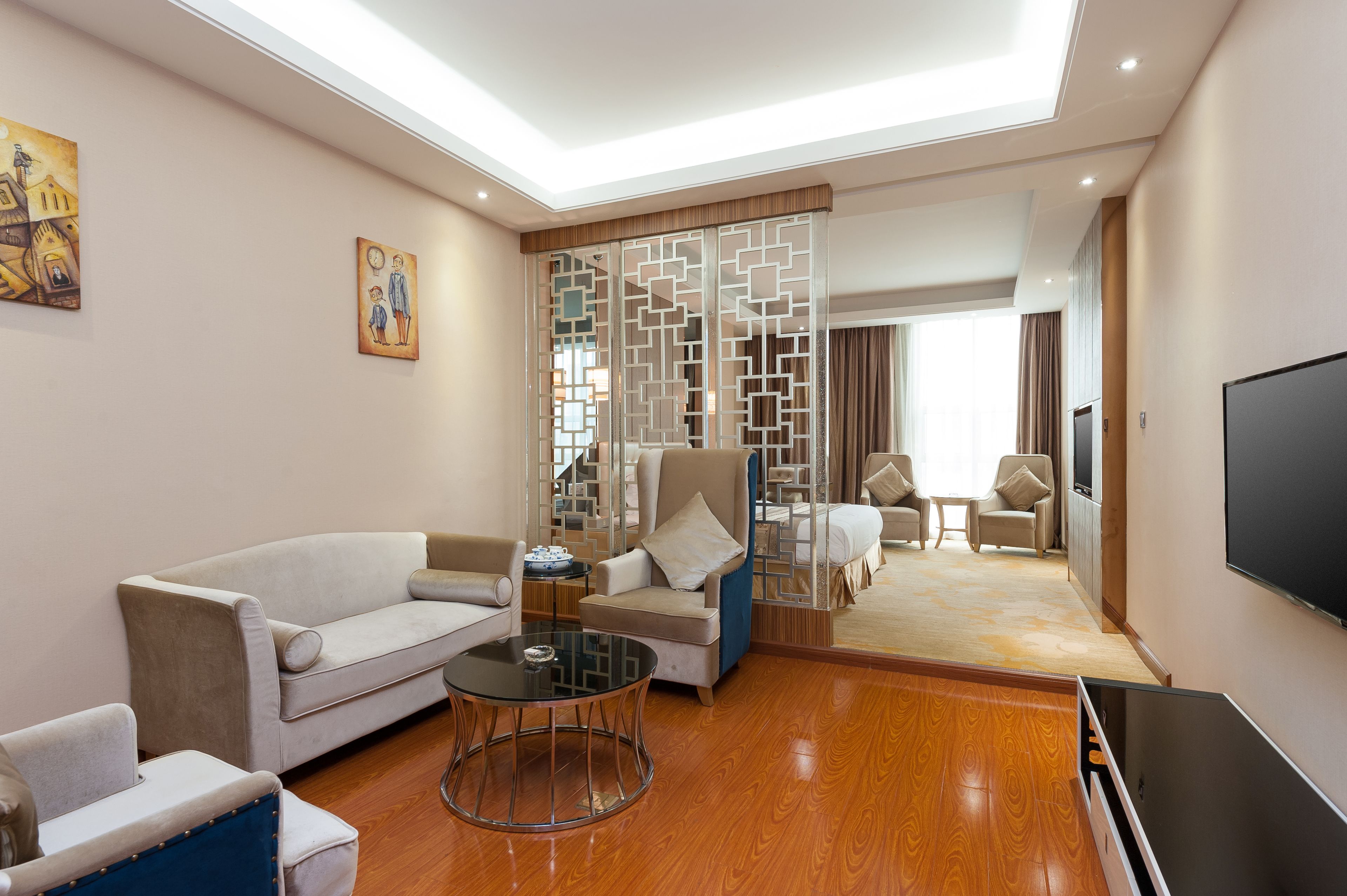 Uma sala de estar moderna com um sofá, poltronas, uma mesa de centro e uma televisão.