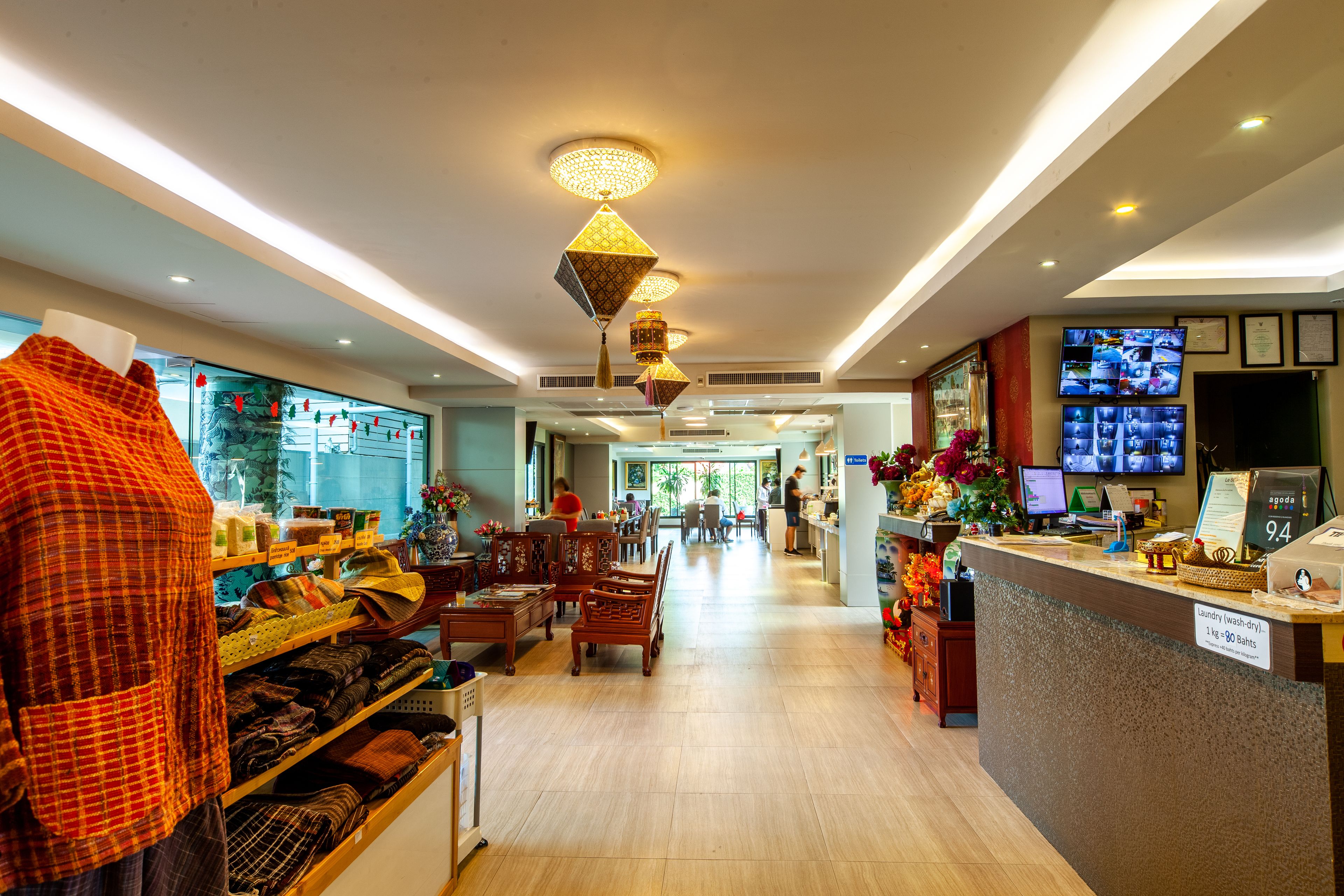 Un hall de hotel con mostrador de recepción, zona de estar y exhibición de textiles.