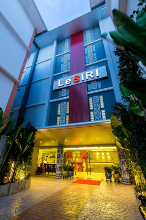 A hotel entrance with a modern facade, a prominent sign, and a well-lit reception area. - Rung Aroon Hotel By Le Siri (Chiang Mai)