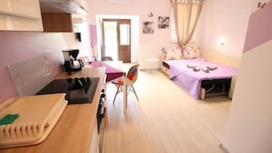 A compact hotel room with a kitchenette, a single bed, and a small sitting area. - Apartments Palma (Rovinj)