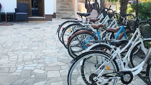 A row of bicycles parked outside a building with a tiled patio. - Apartments Palma (Rovinj)