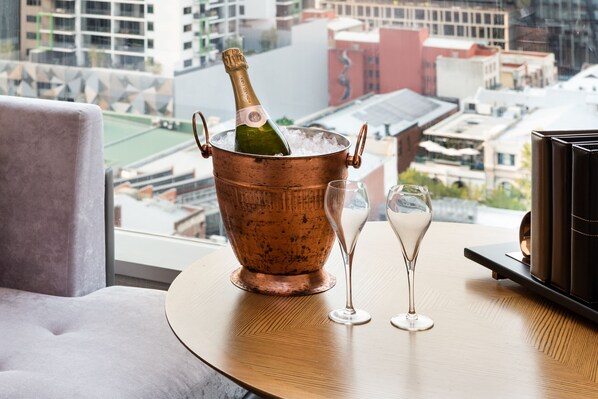 A copper ice bucket with a champagne bottle and two glasses on a round table with a city view. - InterContinental Perth City Centre by IHG (Perth)