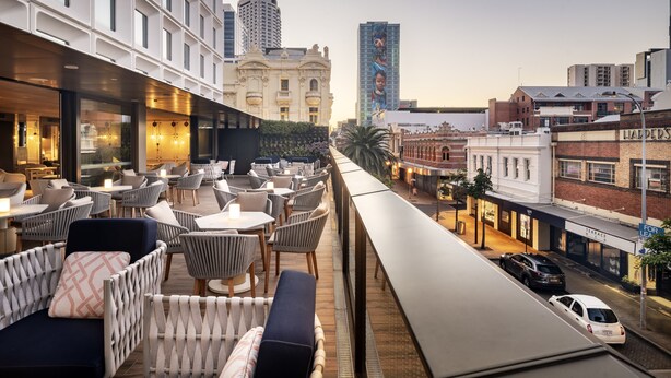 A rooftop bar with outdoor seating, overlooking a city street with buildings and cars. - InterContinental Perth City Centre by IHG (Perth)