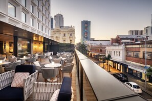 A rooftop bar with outdoor seating, overlooking a city street with buildings and cars. - InterContinental Perth City Centre by IHG (Perth)