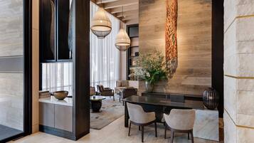 Un comedor moderno con una pared de acento de madera, un jarrón con flores y un portátil sobre la mesa.