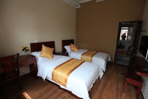 Ein Hotelzimmer mit zwei Betten, Holzmöbeln, einem Schreibtisch und einem Spiegel.