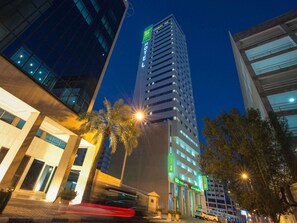 A high-rise hotel with a prominent 'ibis' sign, modern architecture, and a well-lit entrance. - ibis Styles Manama Diplomatic Area (Manama)