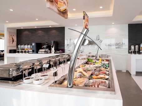 A buffet setup with various food items and a coffee station.