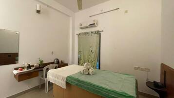 Cozy retreat with a single bed, bedside table, and desk, perfect for a relaxing stay.