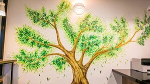 A wall mural of a tree with a light fixture above it. - Urban Inn, Jitra (Jitra)