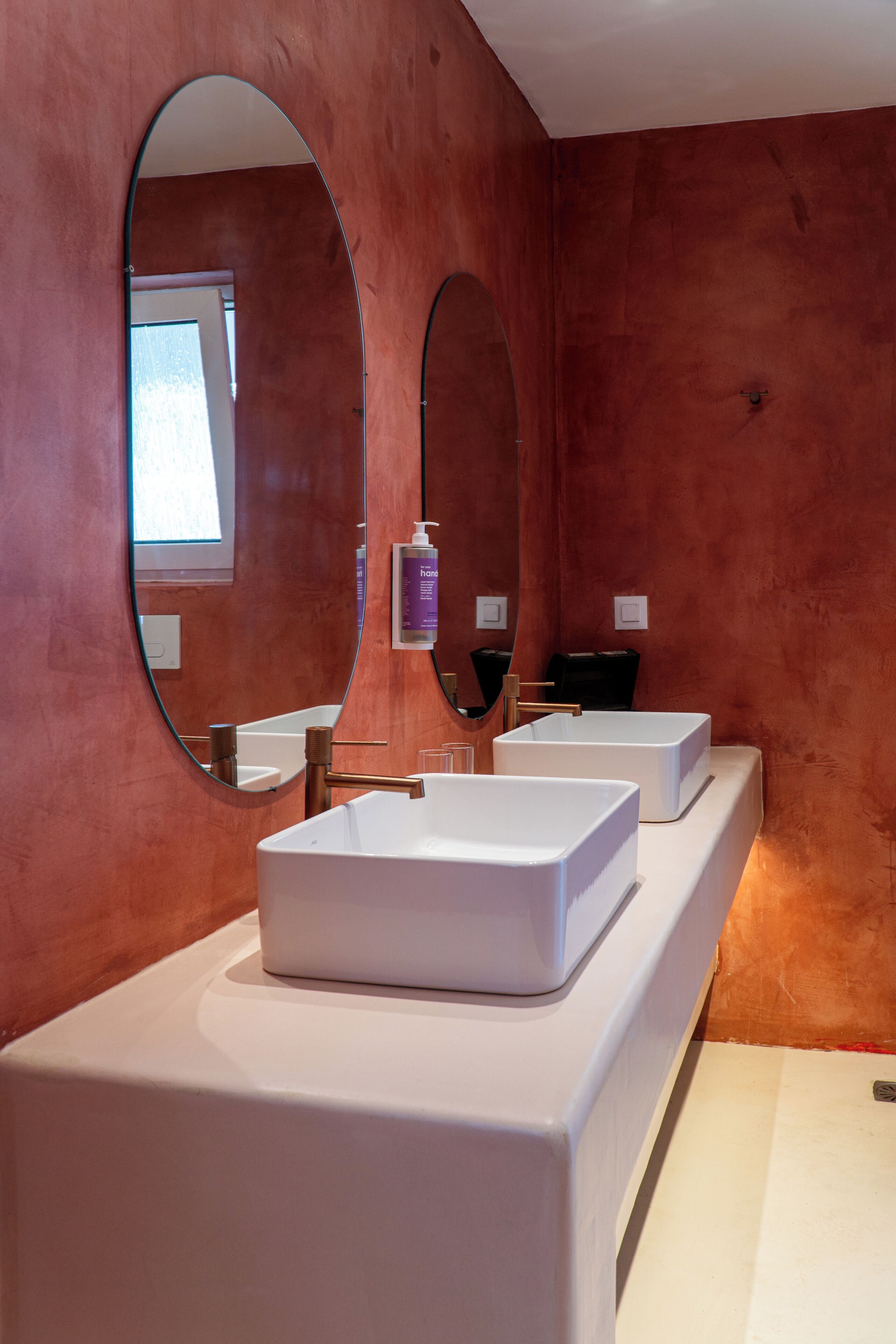 A bathroom with a white vanity, two sinks, and two large mirrors.