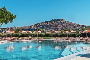 Una piscina al aire libre de temporada, sombrillas