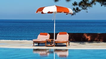 Una piscina al aire libre de temporada, sombrillas