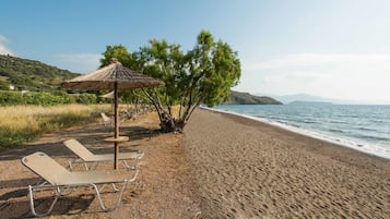 On the beach, black sand, sun loungers, beach umbrellas