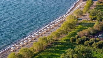 En la playa, playa de arena negra, camastros y sombrillas