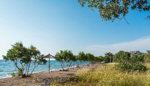 Am Strand, schwarzer Sandstrand, Liegestühle, Sonnenschirme