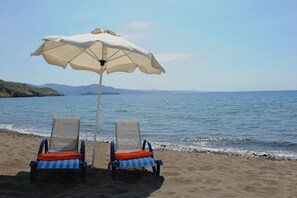 Plage, sable noir, chaises longues, parasols