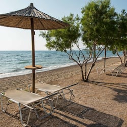 On the beach, black sand, sun-loungers, beach umbrellas