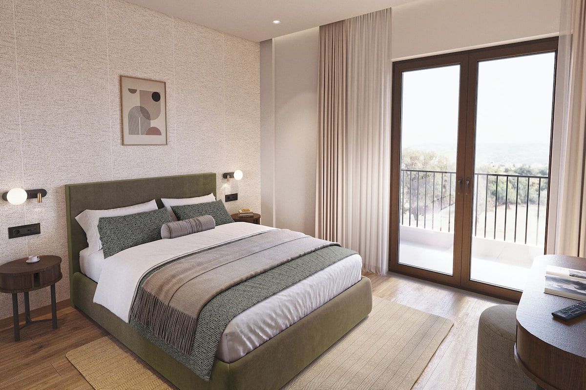 A modern hotel room with a large bed, a view of the outdoors, and a balcony.