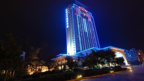 A tall hotel building with illuminated signage and a prominent entrance.