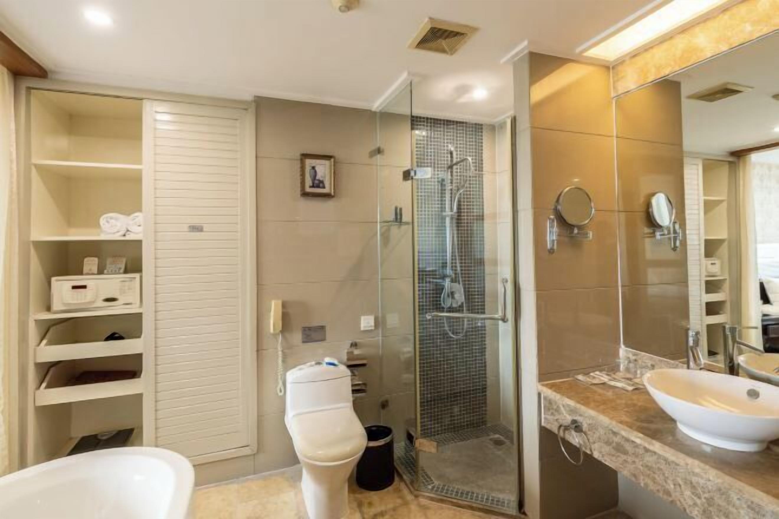 Une salle de bain moderne avec une douche à parois de verre, une baignoire blanche et un grand miroir.