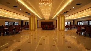 A spacious, well-lit banquet hall with a polished floor, elegant chandeliers, and rows of tables and chairs. - Longyuan Northern Base (Yichun)