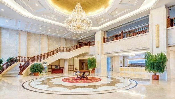 A spacious lobby with a grand chandelier, a central round table, and a staircase leading to an upper level. - Longyuan Northern Base (Yichun)