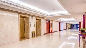 A spacious, well-lit hallway with marble walls and a polished floor, leading to elevators and rooms. - Longyuan Northern Base (Yichun)