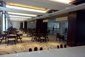 A hotel conference room with rows of chairs, a patterned carpet, and a modern ceiling design. - Longyuan Northern Base (Yichun)
