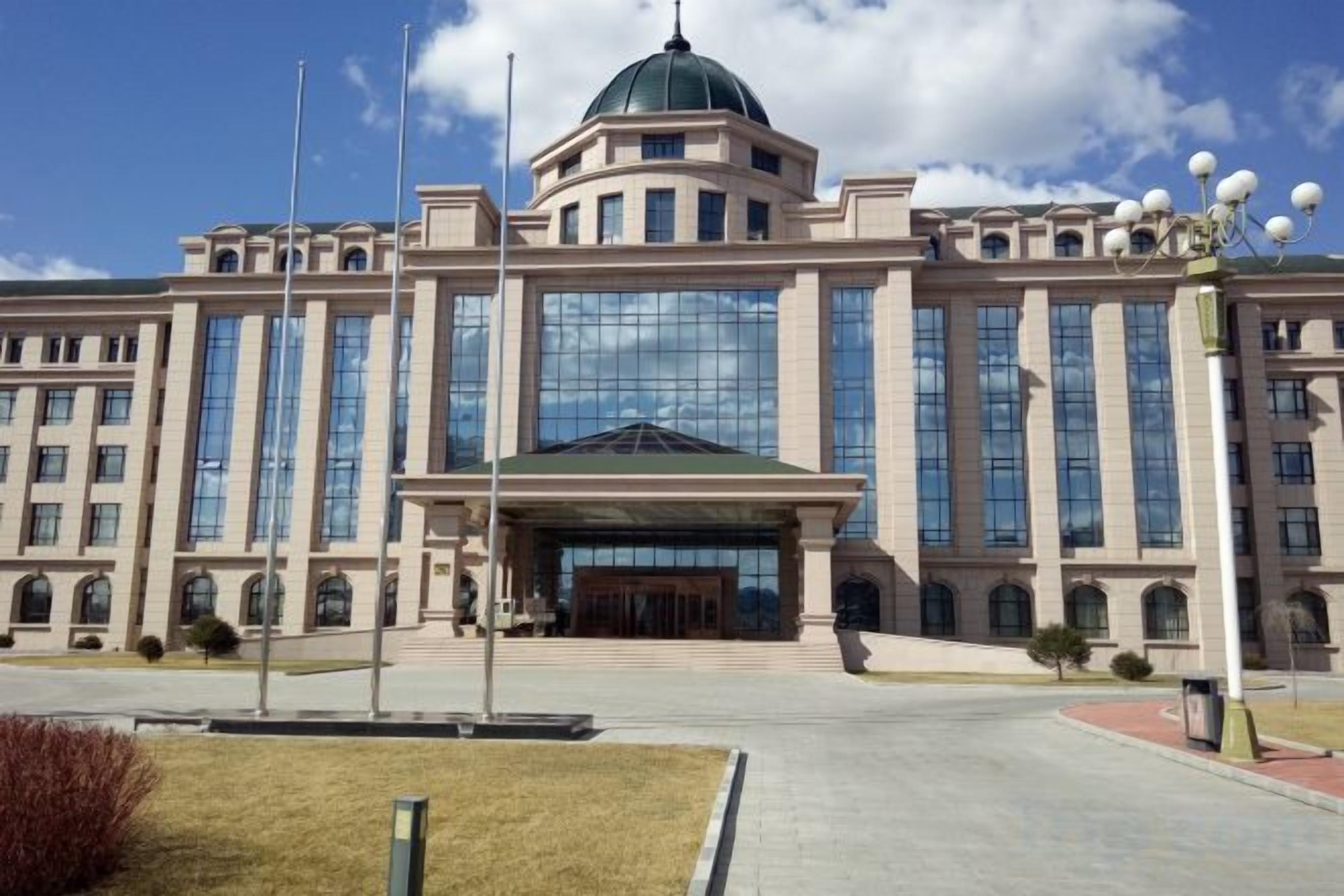 A large, multi-story building with a central dome and symmetrical architecture.