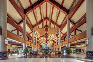 Um hall amplo com pé direito alto, grandes lustres e design simétrico.
