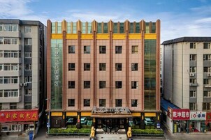 A multi-story building with a central entrance, surrounded by other buildings.
