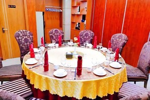 A round table with a yellow tablecloth, surrounded by purple upholstered chairs. - Elong Wanguo Hotel (Liaoyuan Railway Station Traditional Chinese Medicine Hospital) (Liaoyuan)