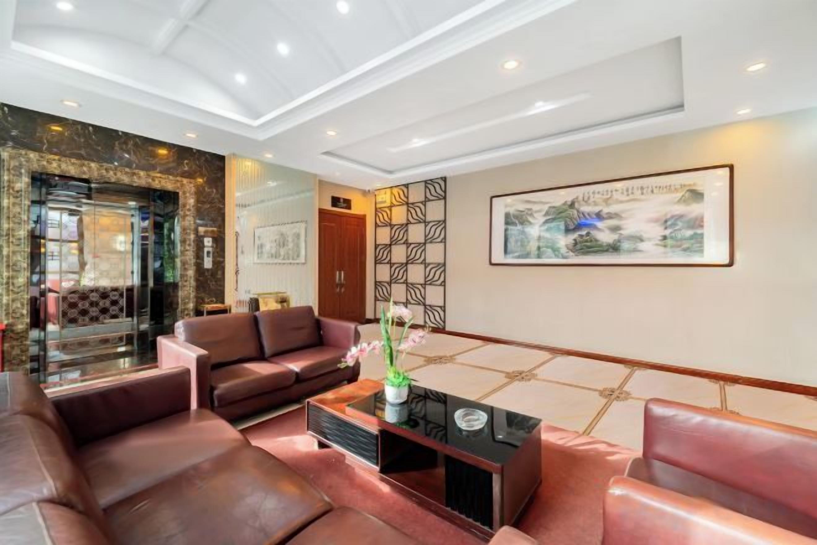 A hotel lobby with leather sofas, a coffee table, and artwork on the walls.