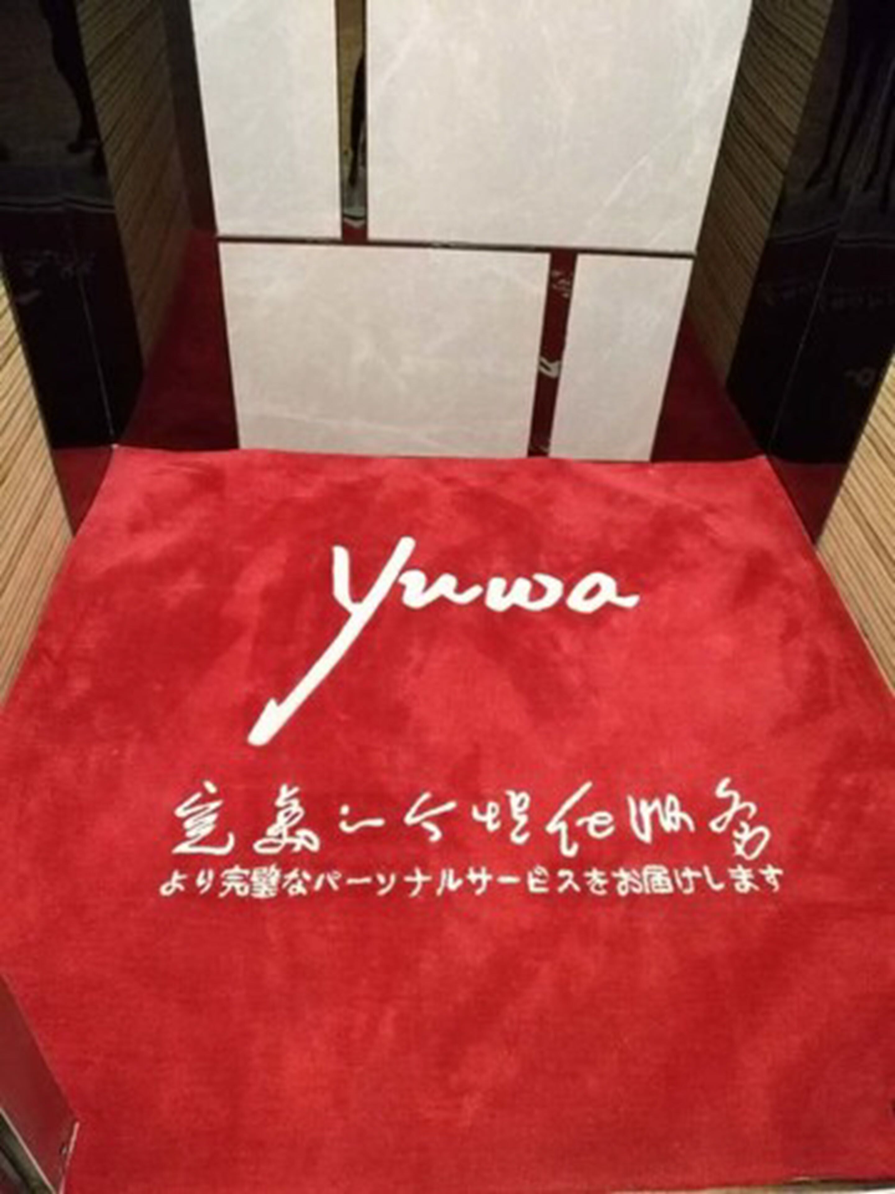 A red carpet with the name 'Yuwa' and Japanese text, indicating a hotel or establishment.