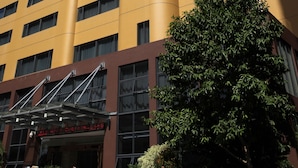 Un hotel de varios pisos con fachada amarilla y numerosas ventanas.