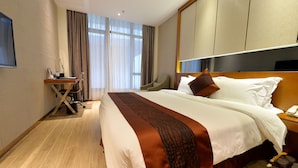 Una habitación de hotel con una cama grande, un escritorio y una silla.
