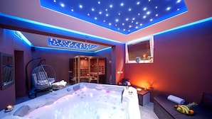 A modern spa room with a hot tub, a massage chair, and a small seating area with fruit. - Hotel Stella Maris (Vodice)
