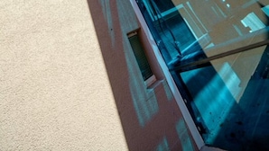 A modern building with reflective glass facade and a clear sky. - Hotel Stella Maris (Vodice)