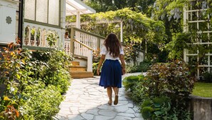 Un chemin menant à un bâtiment à la façade blanche et à l’entrée abritée.