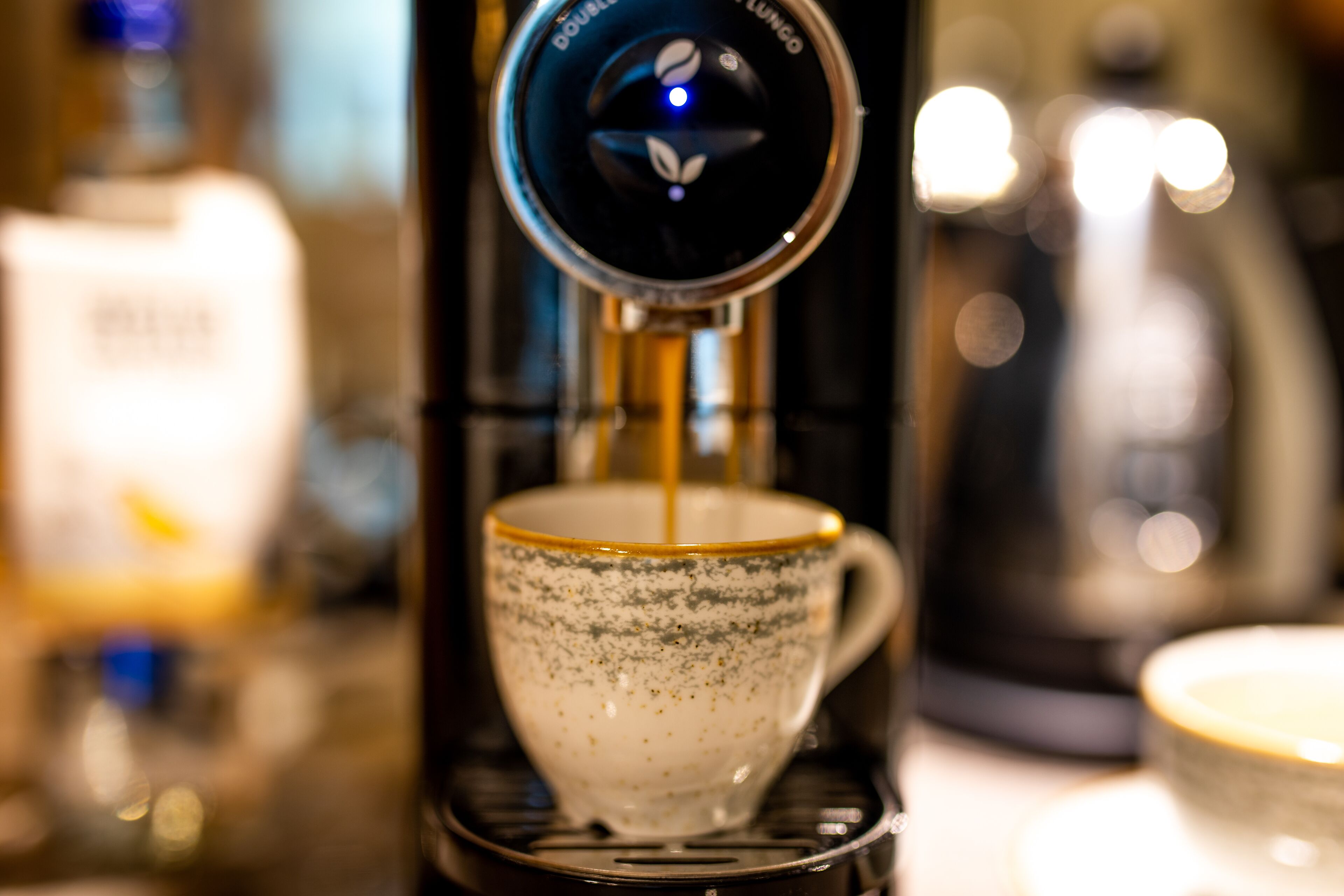 A coffee machine dispensing coffee into a cup.