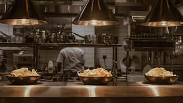 A kitchen with three bowls of chips under pendant lights.