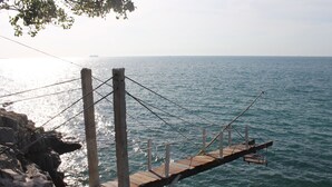 A wooden pier extending over calm water, supported by wooden posts and metal cables. - Koh Sichang Unseen (Ko Sichang)