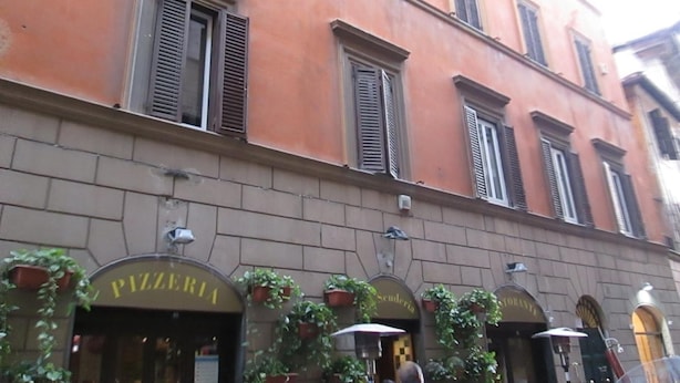 A building with multiple storefronts, including a pizzeria. - Trevi Elegance Suite (Rome)