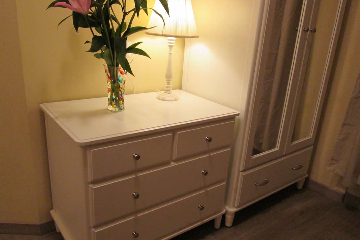 A white dresser with three drawers and a mirror cabinet.
